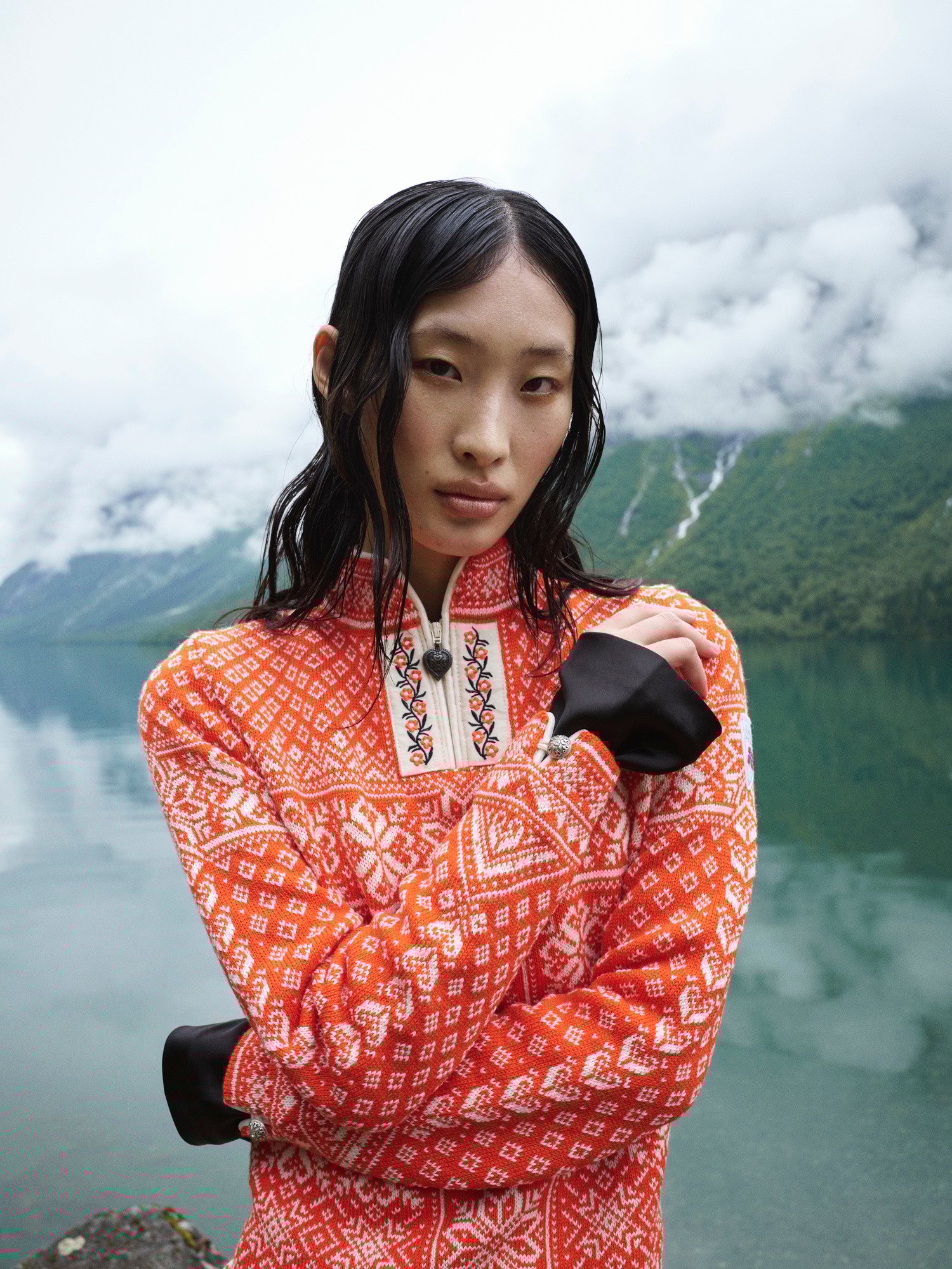 Female mode wearing Dale of Norway wool sweater standing by the Norwegian fjords